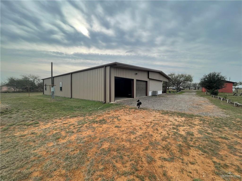 241 Delmita Road Delmita, TX 78536 - Photo 6 of 7 View of outbuilding with a yard, a garage, and central AC