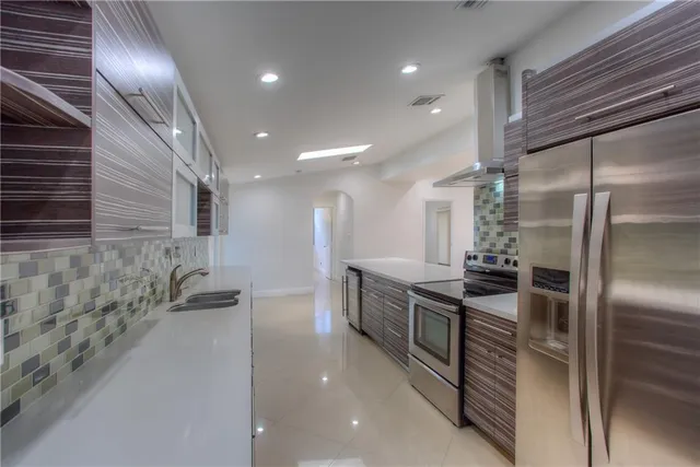 a kitchen with granite countertop a refrigerator and a sink