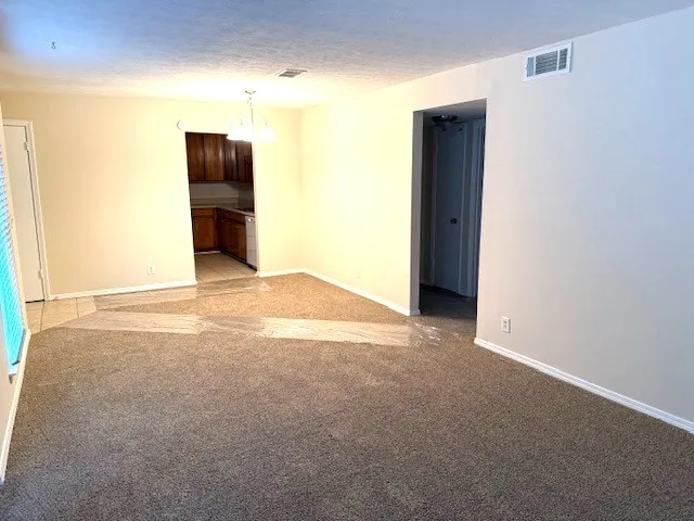 a view of an empty room with a kitchen
