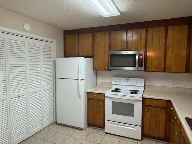 a kitchen with a refrigerator stove and microwave