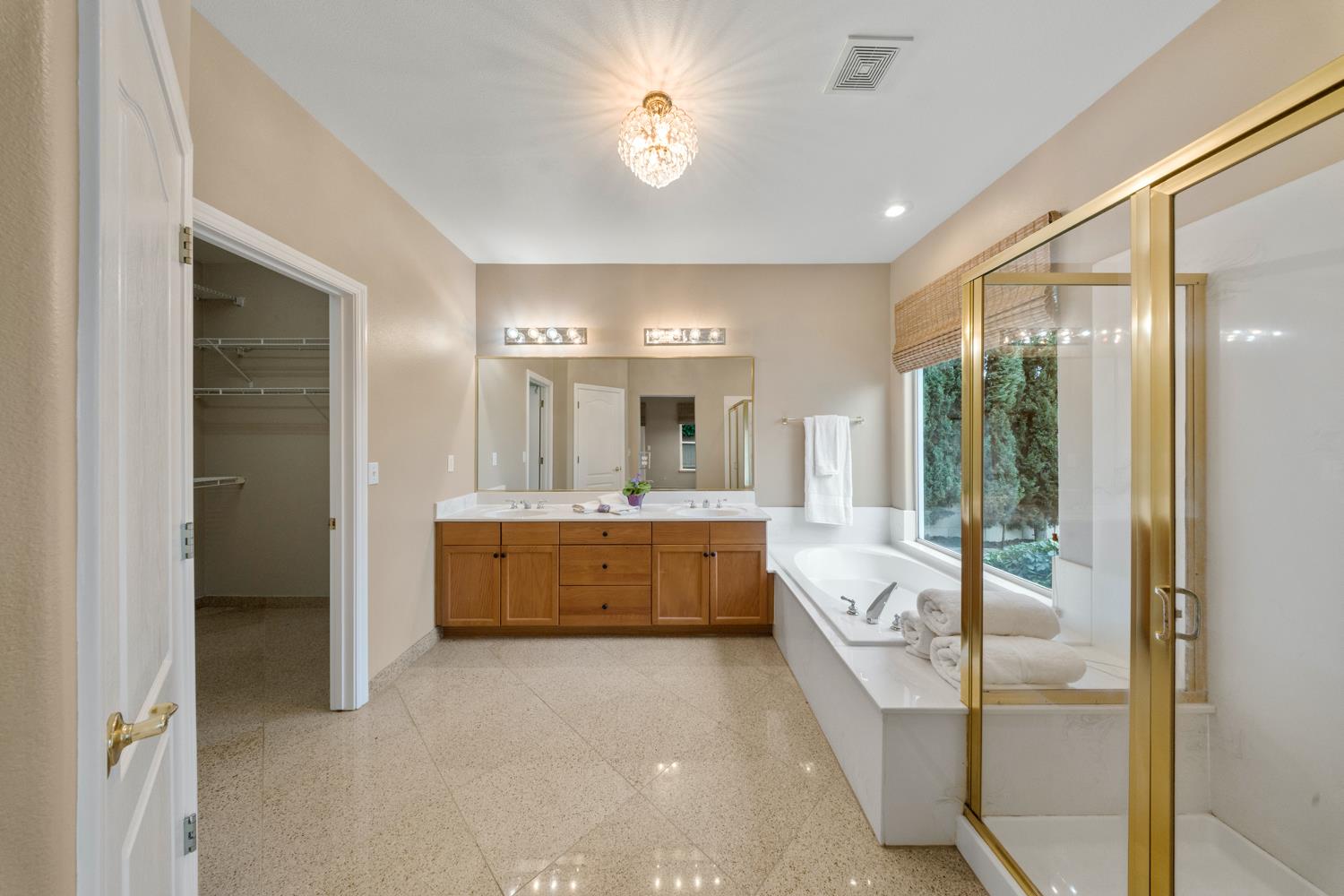 4601 Vía Altura Modesto, CA 95357 - Photo 20 of 30 a bathroom with a double vanity sink a large mirror and a bathtub