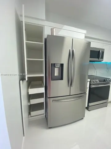 a metallic refrigerator freezer and a refrigerator in a kitchen