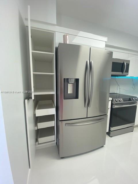 3530 Mystic Pointe Drive, Unit 2503 Aventura, FL 33180 - Photo 11 of 24 a metallic refrigerator freezer and a refrigerator in a kitchen