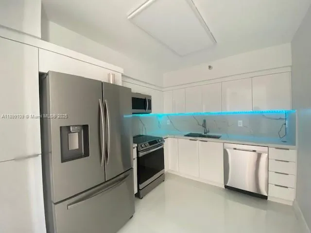 a kitchen with stainless steel appliances granite countertop a refrigerator and a stove