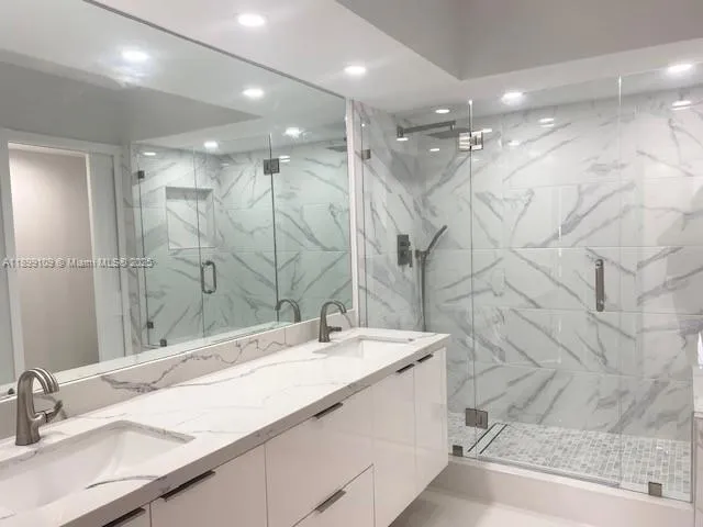 a bathroom with a double vanity sink mirror and shower