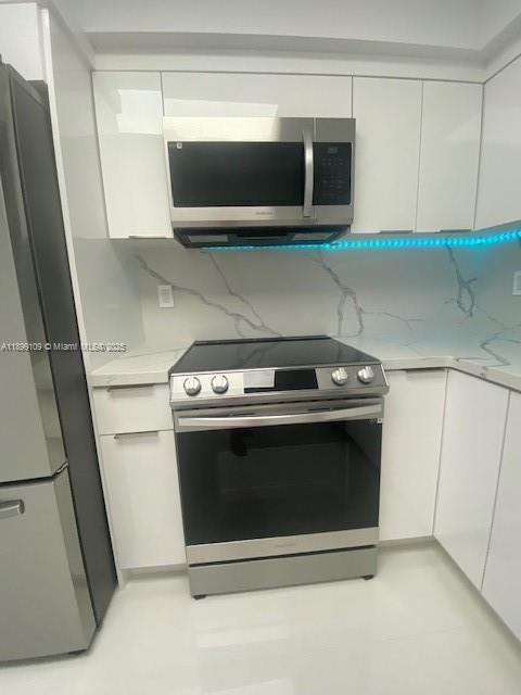 3530 Mystic Pointe Drive, Unit 2503 Aventura, FL 33180 - Photo 14 of 24 a stove top oven sitting inside of a kitchen