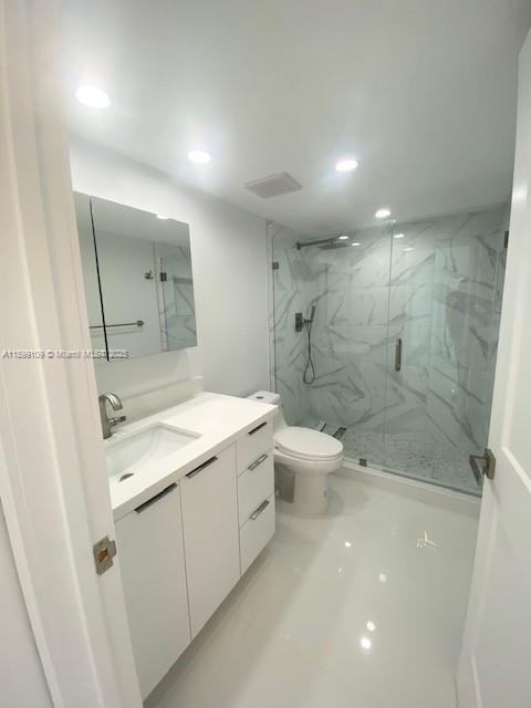 3530 Mystic Pointe Drive, Unit 2503 Aventura, FL 33180 - Photo 3 of 24 a bathroom with a granite countertop sink a toilet and shower