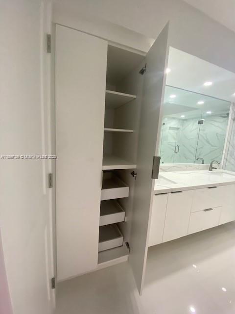 3530 Mystic Pointe Drive, Unit 2503 Aventura, FL 33180 - Photo 5 of 24 a bathroom with a double vanity sink a toilet and a shower