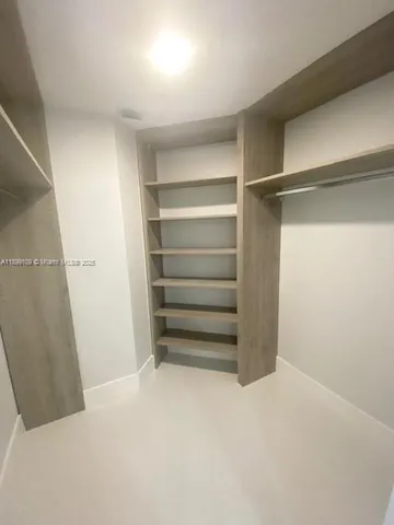 a view of walk in closet with empty racks