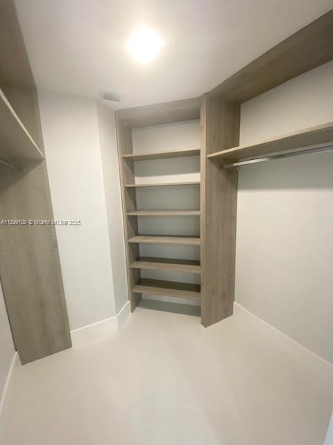 3530 Mystic Pointe Drive, Unit 2503 Aventura, FL 33180 - Photo 7 of 24 a view of walk in closet with empty racks