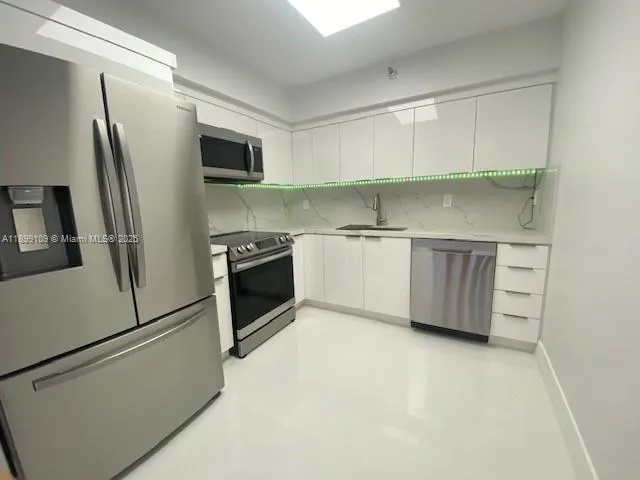 a kitchen with stainless steel appliances a refrigerator sink and microwave