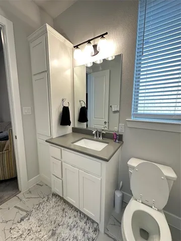 a bathroom with a toilet sink and mirror