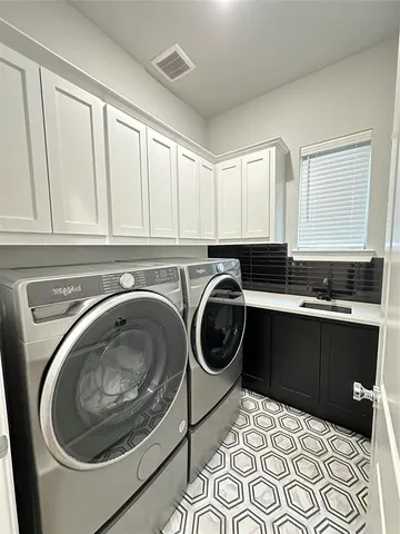 a utility room with sink dryer and washer