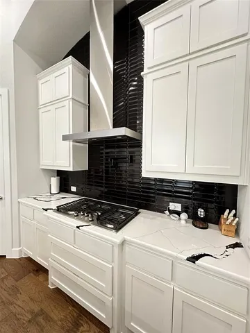 a kitchen with white cabinets and appliances