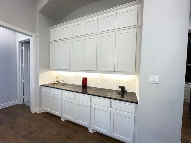 a kitchen with white cabinets and sink