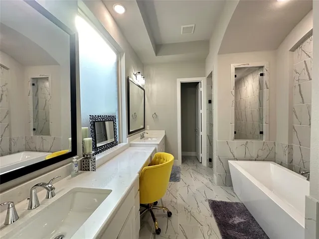 a bathroom with a granite countertop sink and a bathtub