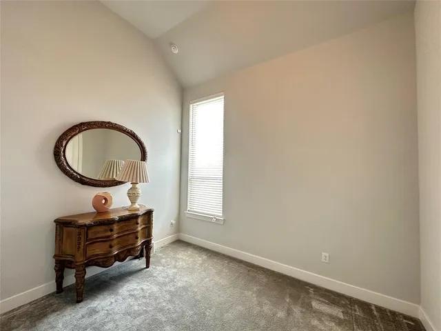 a room with a desk a chair and a window