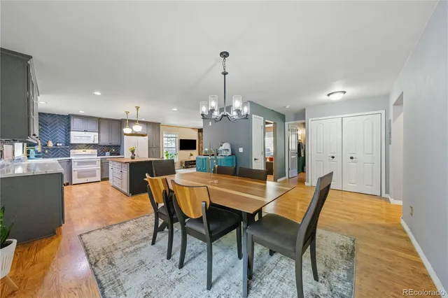 a dining room with furniture a chandelier and wooden floor