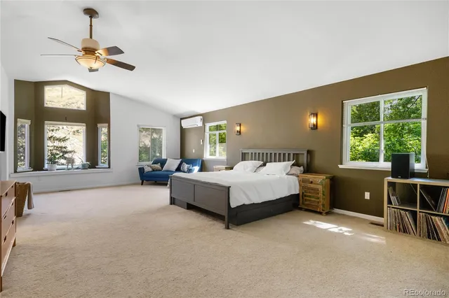 a spacious bedroom with a large bed and a chandelier