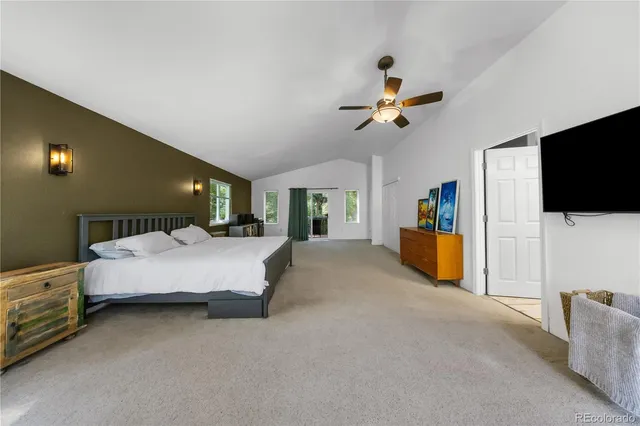 a spacious bedroom with a bed and a flat screen tv