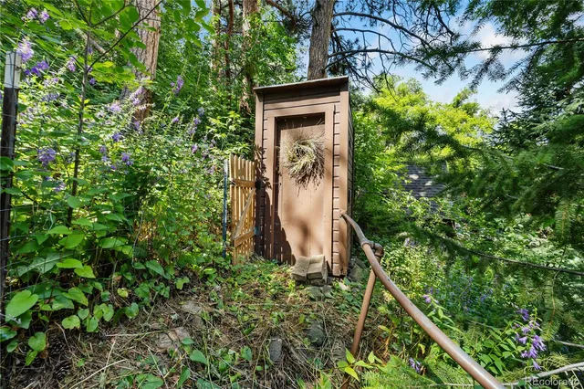 a view of a patio with table and chairs potted plants and large tree