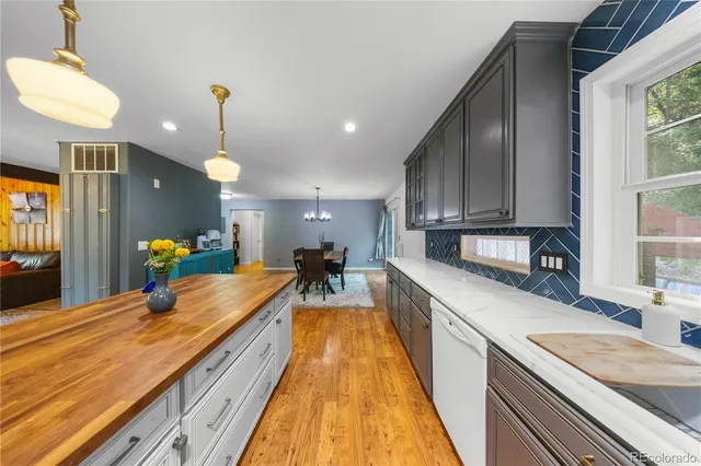 a large kitchen with kitchen island a large counter top space a sink stainless steel appliances and cabinets
