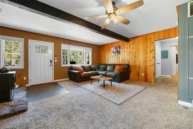 a living room with furniture a ceiling fan and a window