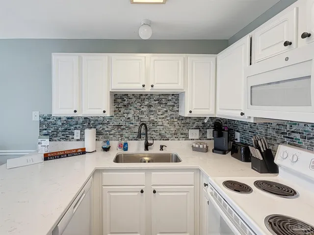 a kitchen with a sink a stove and cabinets