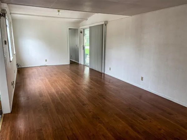 an empty room with wooden floor and a window