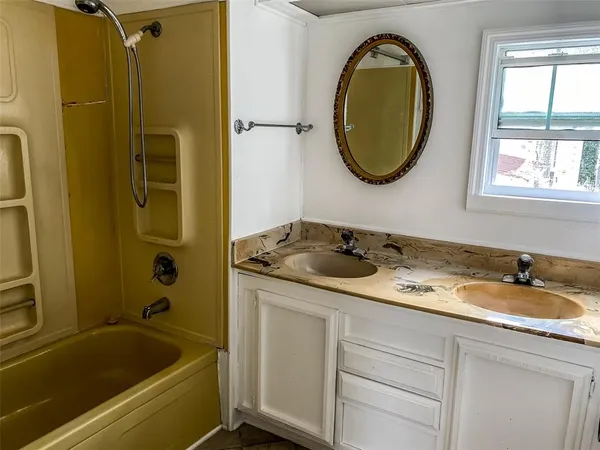 a bathroom with a tub sink and mirror