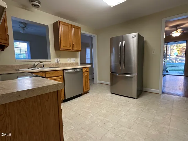 a kitchen with stainless steel appliances granite countertop a refrigerator and a sink