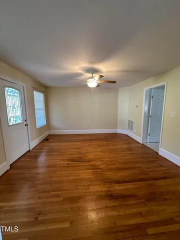 a view of a room with wooden floor and window