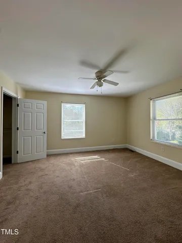 an empty room with windows and closet