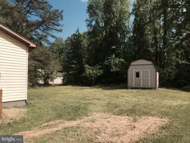 a view of a house with a yard and large tree
