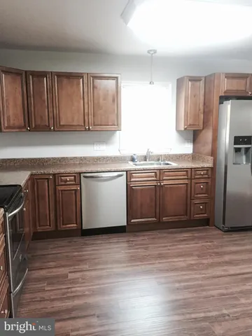 a kitchen with stainless steel appliances granite countertop a stove a sink dishwasher and a refrigerator