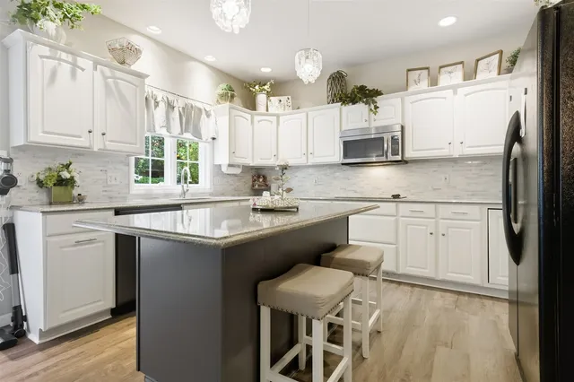 a kitchen with cabinets appliances a sink and a counter top space