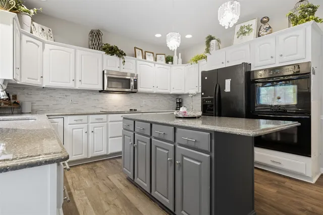 a kitchen with granite countertop a sink stove and refrigerator