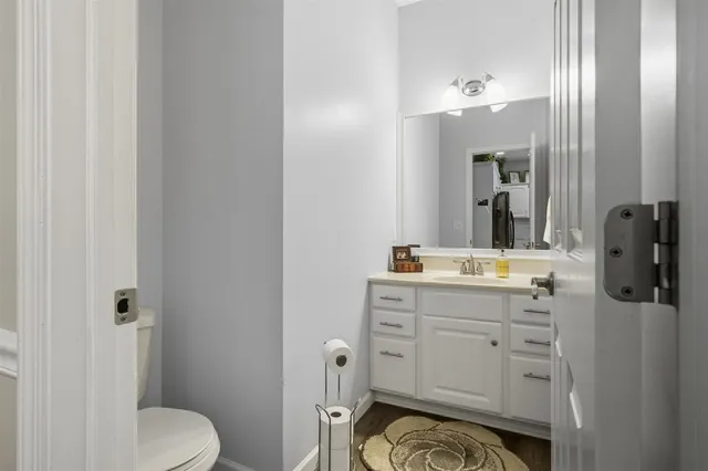 a bathroom with a granite countertop sink toilet and mirror