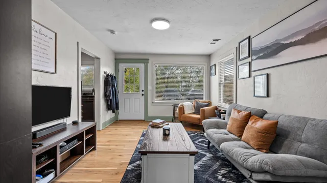 a living room with furniture a flat screen tv and a large window