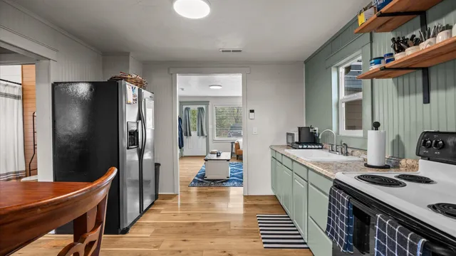 a kitchen with stainless steel appliances granite countertop a sink stove and refrigerator
