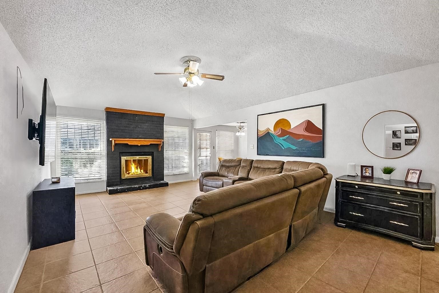 16230 Katherine Lane Channelview, TX 77530 - Photo 5 of 18 a living room with furniture a fireplace and a flat screen tv