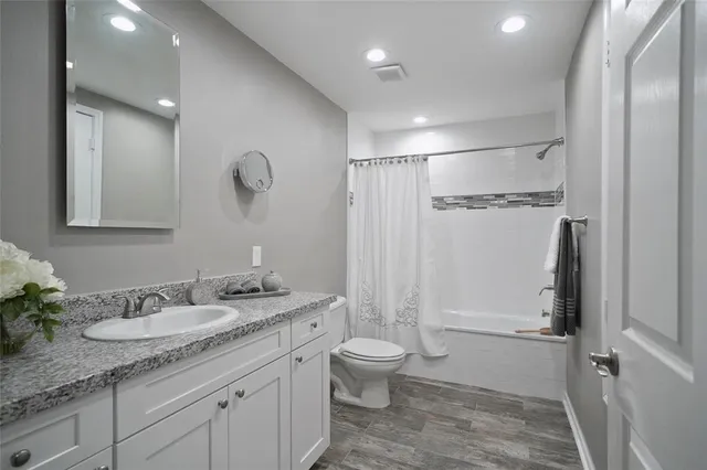 a bathroom with a granite countertop sink toilet and shower
