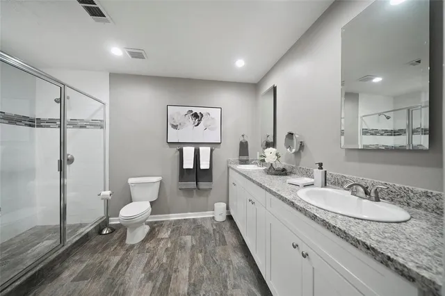 a spacious bathroom with a granite countertop sink toilet and shower