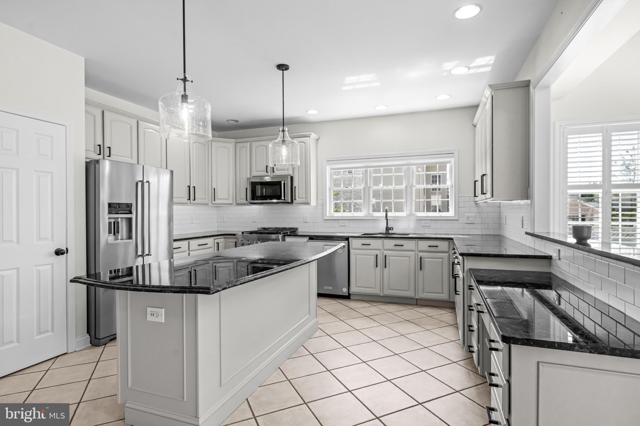 22 Tara Drive Sewell, NJ 08080 - Photo 40 of 70 a kitchen with stainless steel appliances granite countertop a refrigerator a sink dishwasher a stove and white cabinets with wooden floor