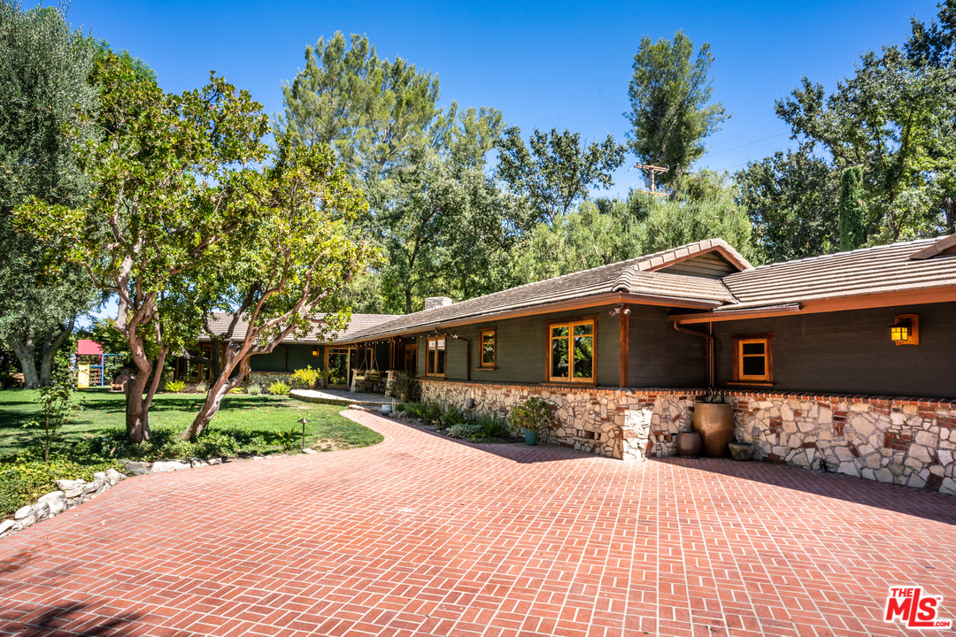 24878 Long Valley Road Hidden Hills, CA 91302 - Photo 23 of 54 a front view of a house with a yard and garage