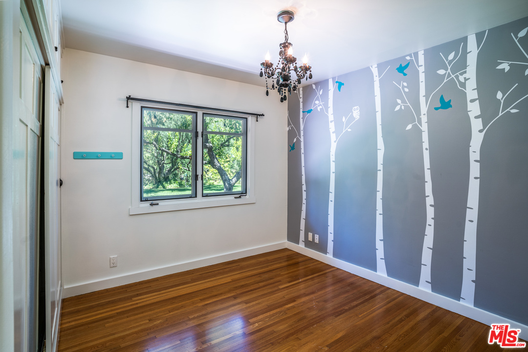 24878 Long Valley Road Hidden Hills, CA 91302 - Photo 36 of 54 a view of a bedroom with wooden floor and windows