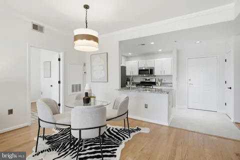 a kitchen with kitchen island stainless steel appliances a dining table and sink