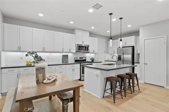 a kitchen with kitchen island granite countertop stainless steel appliances cabinets a sink and a center island