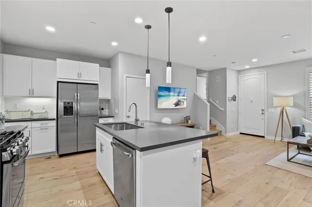 a kitchen with refrigerator and chairs