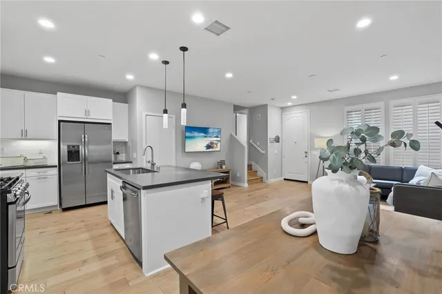 a kitchen with refrigerator and chairs
